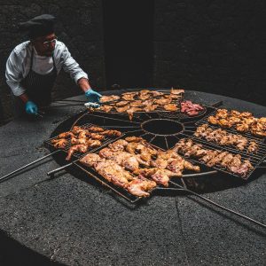male chef standing while roasting chicken